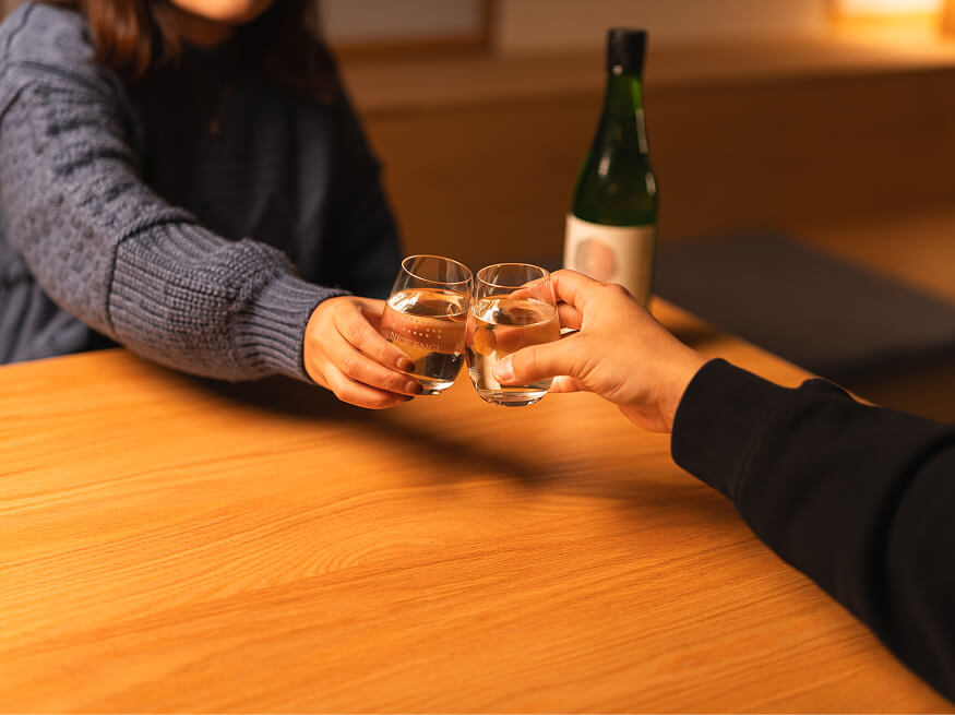 ラウンジ和でお猪口を合わせて乾杯する二人の手元